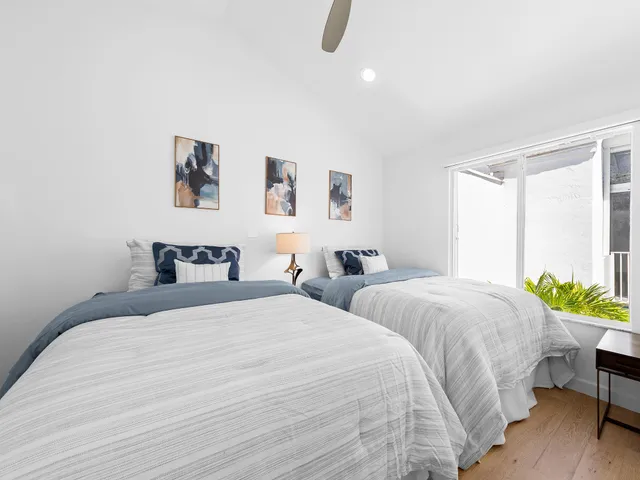 a bedroom with two beds and a chair