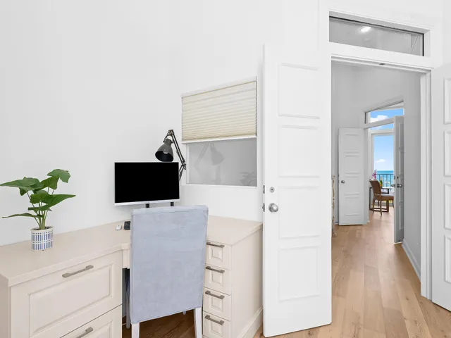 a hallway with a potted plant on the counter and a wooden floor