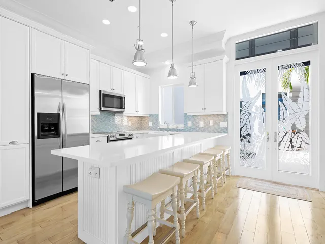 a large kitchen with kitchen island granite countertop a stove a sink a refrigerator and a wooden cabinets