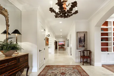 a large white bathroom with a granite countertop double vanity sink a mirror and a bathtub