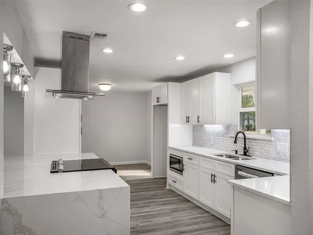 a kitchen with kitchen island a sink stainless steel appliances and cabinets