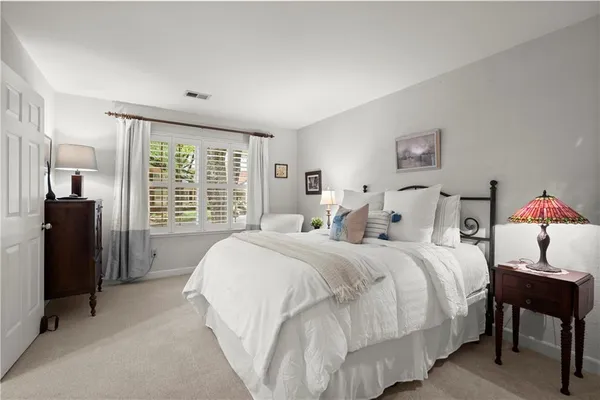 a spacious bedroom with a bed and a large window
