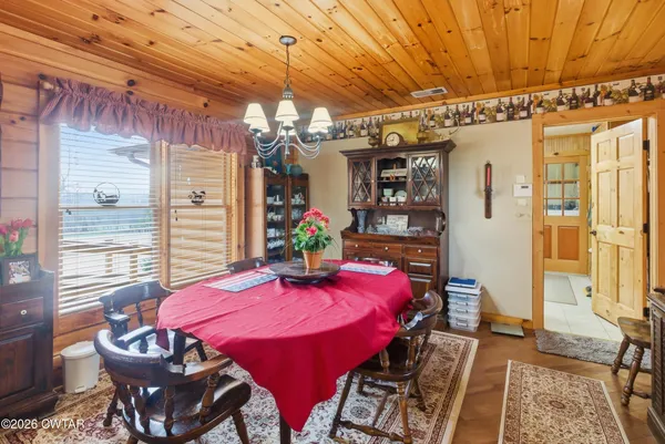 a bedroom with a bed a desk and chair with wooden floor