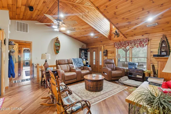 a living room with patio furniture and a chandelier