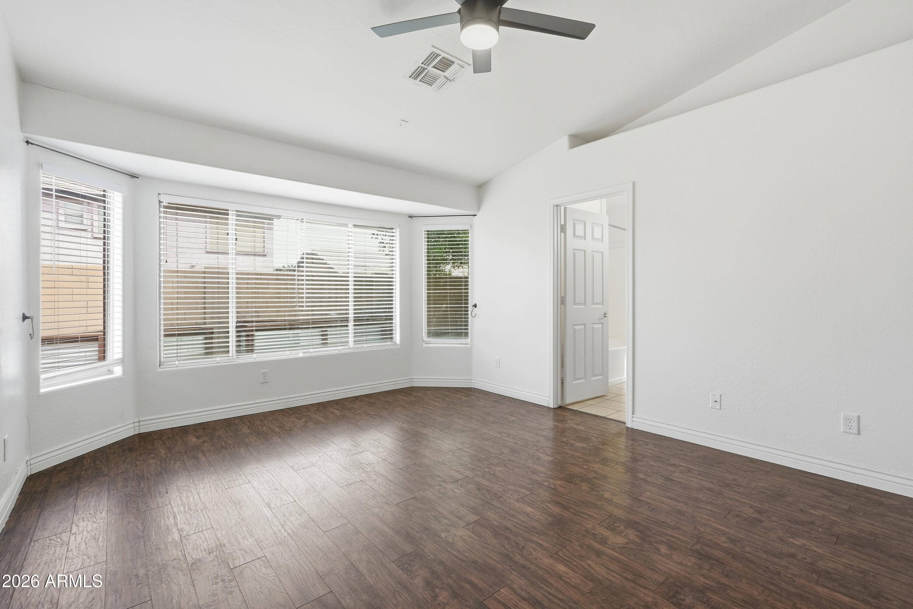 3242 East Bonanza Road Gilbert, AZ 85297 - Photo 14 of 36 a view of an empty room with wooden floor and a window