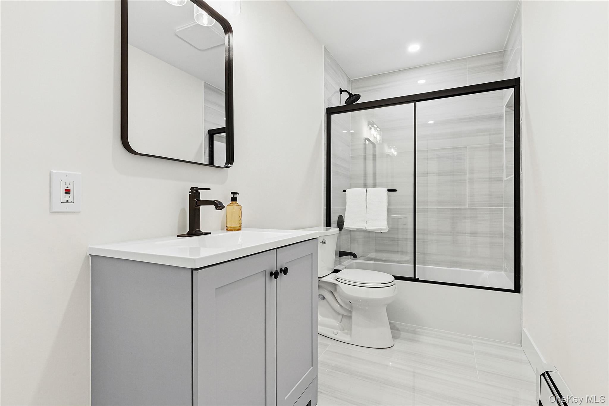 21 A Neulist Avenue Port Washington, NY 11050 - Photo 14 of 17 a bathroom with a toilet sink and mirror