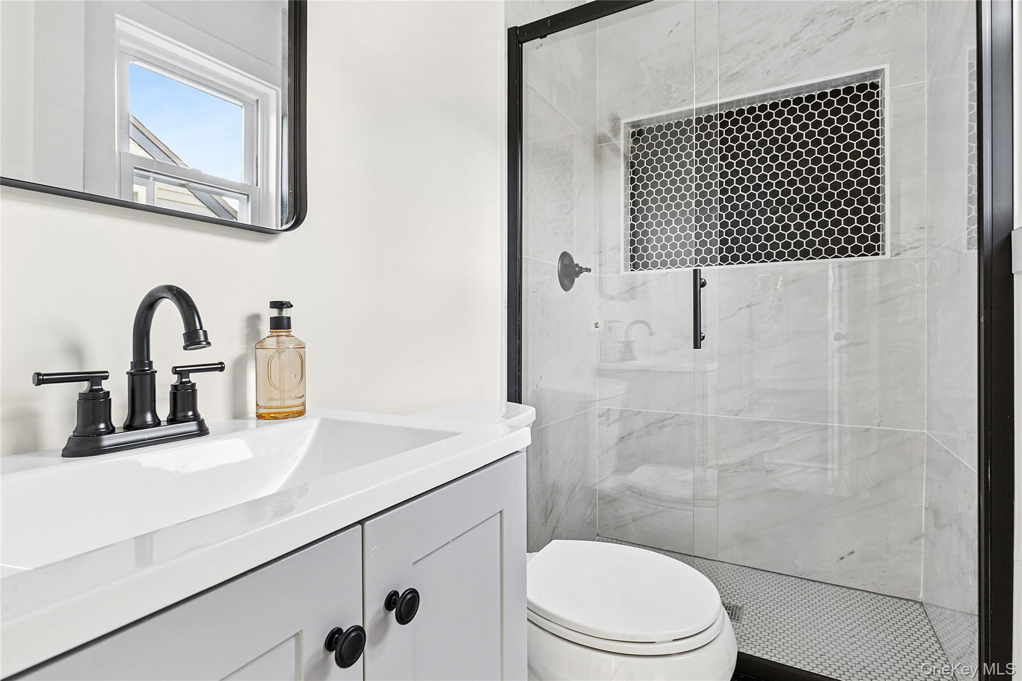 21 A Neulist Avenue Port Washington, NY 11050 - Photo 15 of 17 a bathroom with a sink a toilet and mirror