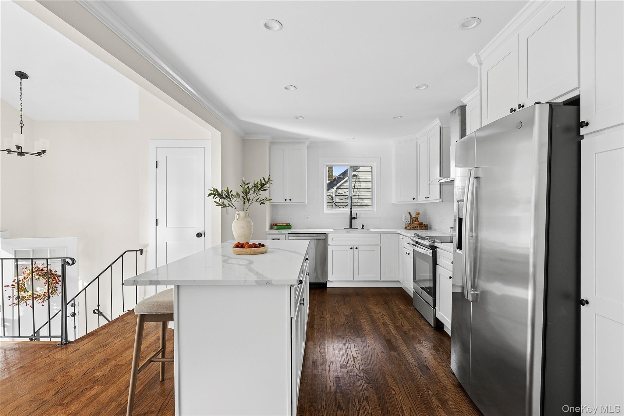 21 A Neulist Avenue Port Washington, NY 11050 - Photo 6 of 17 a kitchen with kitchen island white cabinets and stainless steel appliances