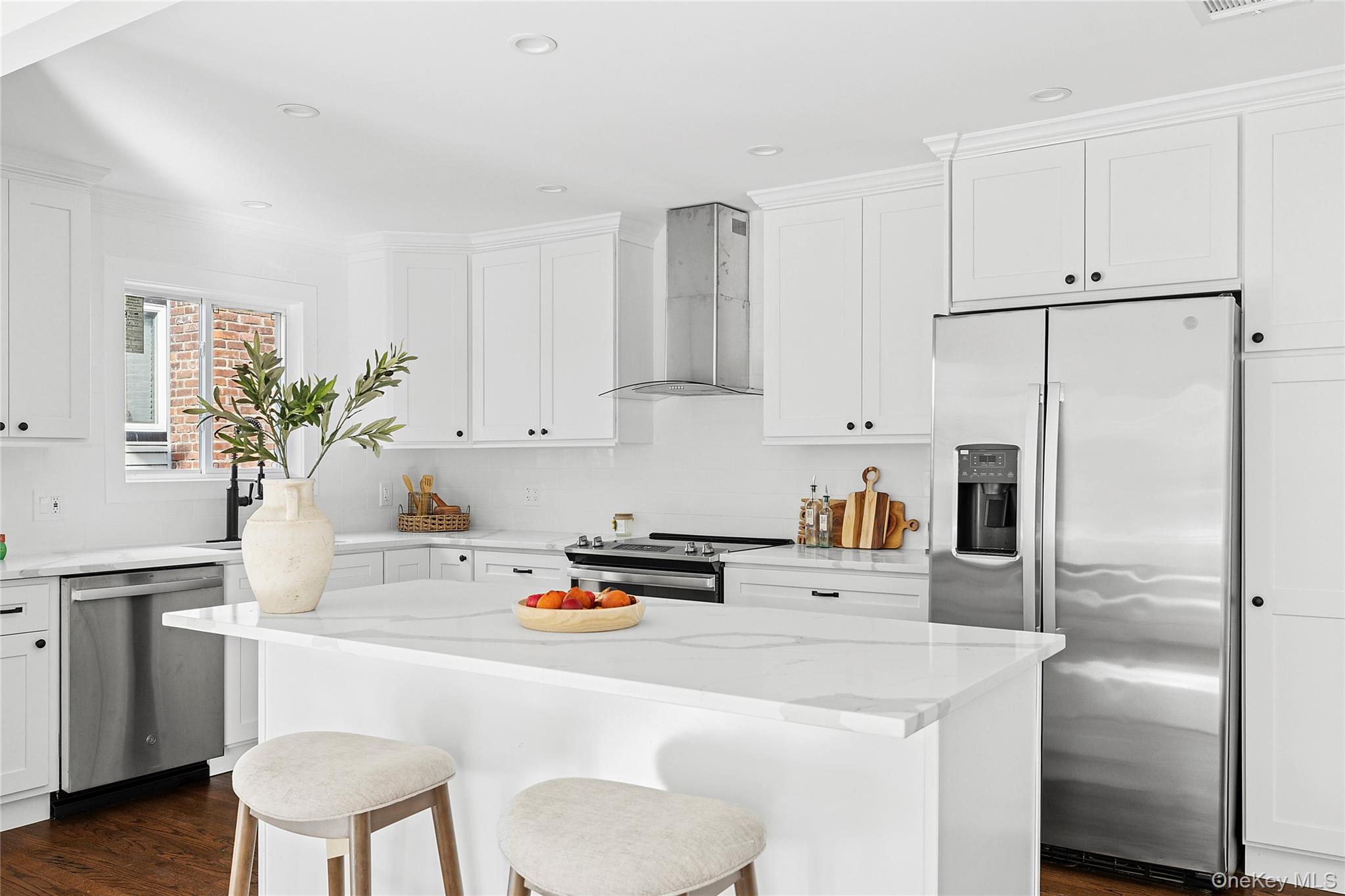 21 A Neulist Avenue Port Washington, NY 11050 - Photo 7 of 17 a kitchen with white cabinets and stainless steel appliances