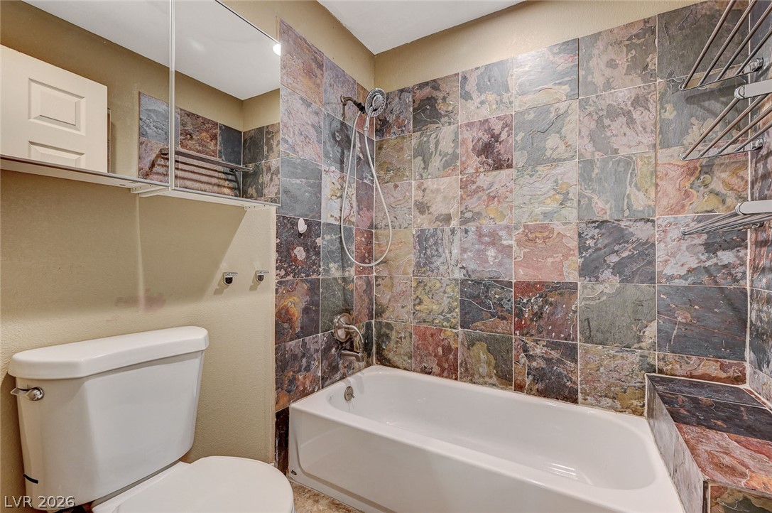 4153 Woodcrest Road Las Vegas, NV 89121 - Photo 26 of 58 Boldly tiled walls create a lively backdrop for a functional bathroom with essential amenities.