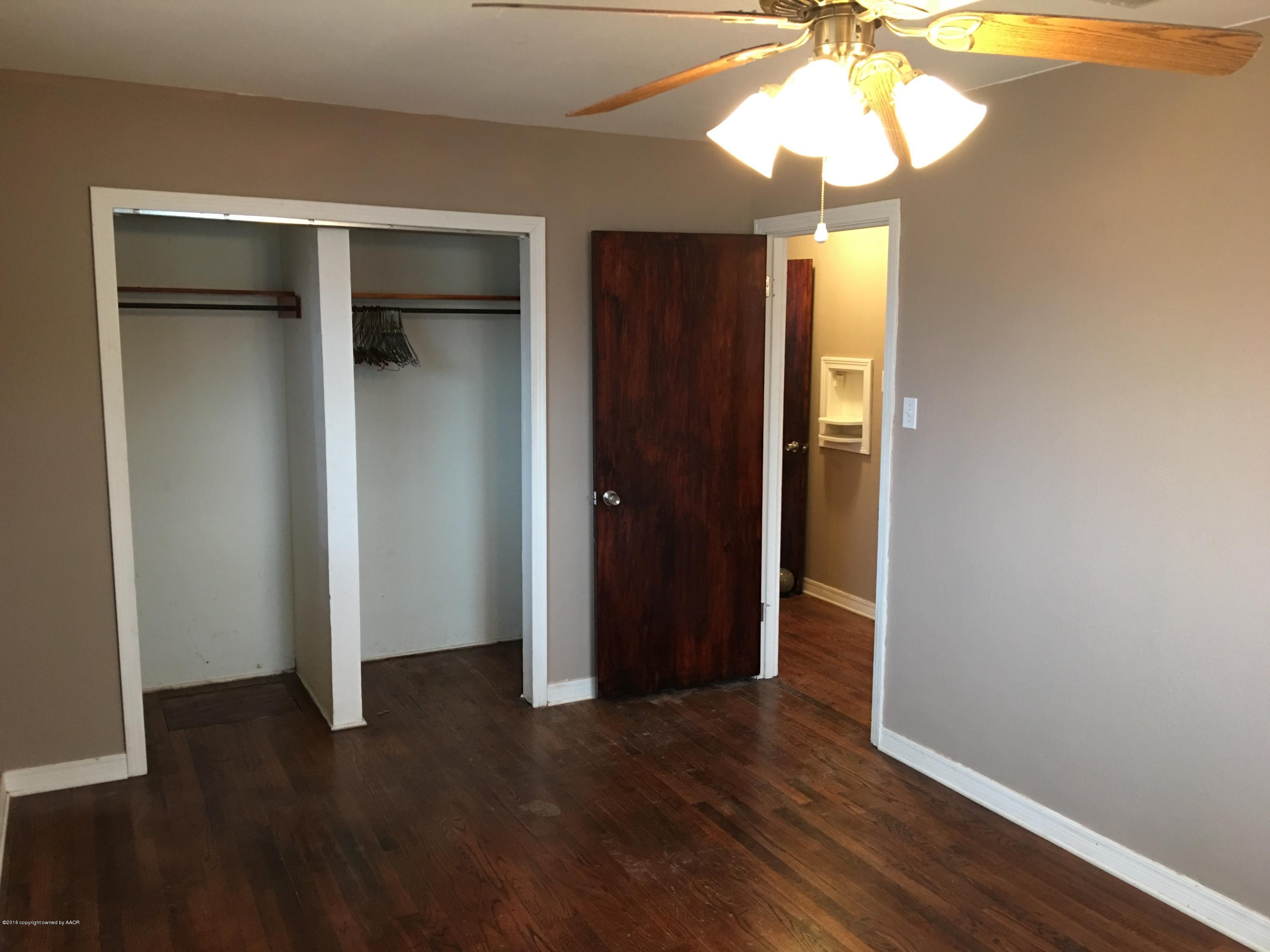 4321 South Travis Street Amarillo, TX 79110 - Photo 11 of 38 an empty room with wooden floor closet and chandelier fan