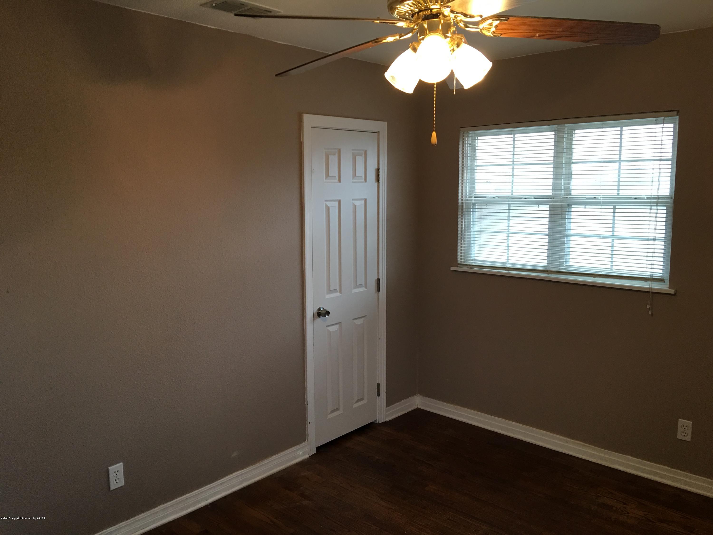 4321 South Travis Street Amarillo, TX 79110 - Photo 14 of 38 an empty room with a window and a chandelier fan
