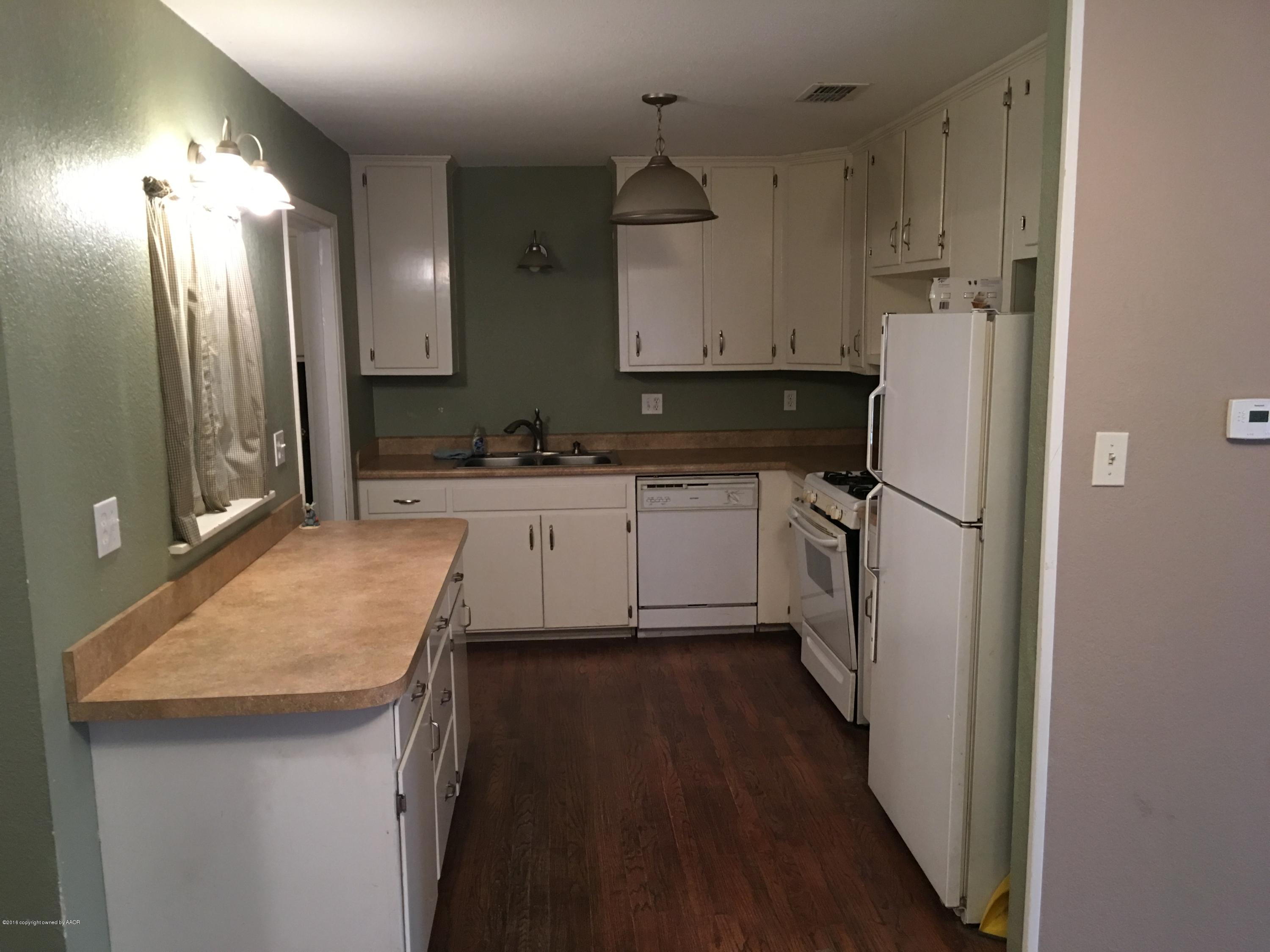 4321 South Travis Street Amarillo, TX 79110 - Photo 18 of 38 a kitchen with refrigerator a sink and cabinets
