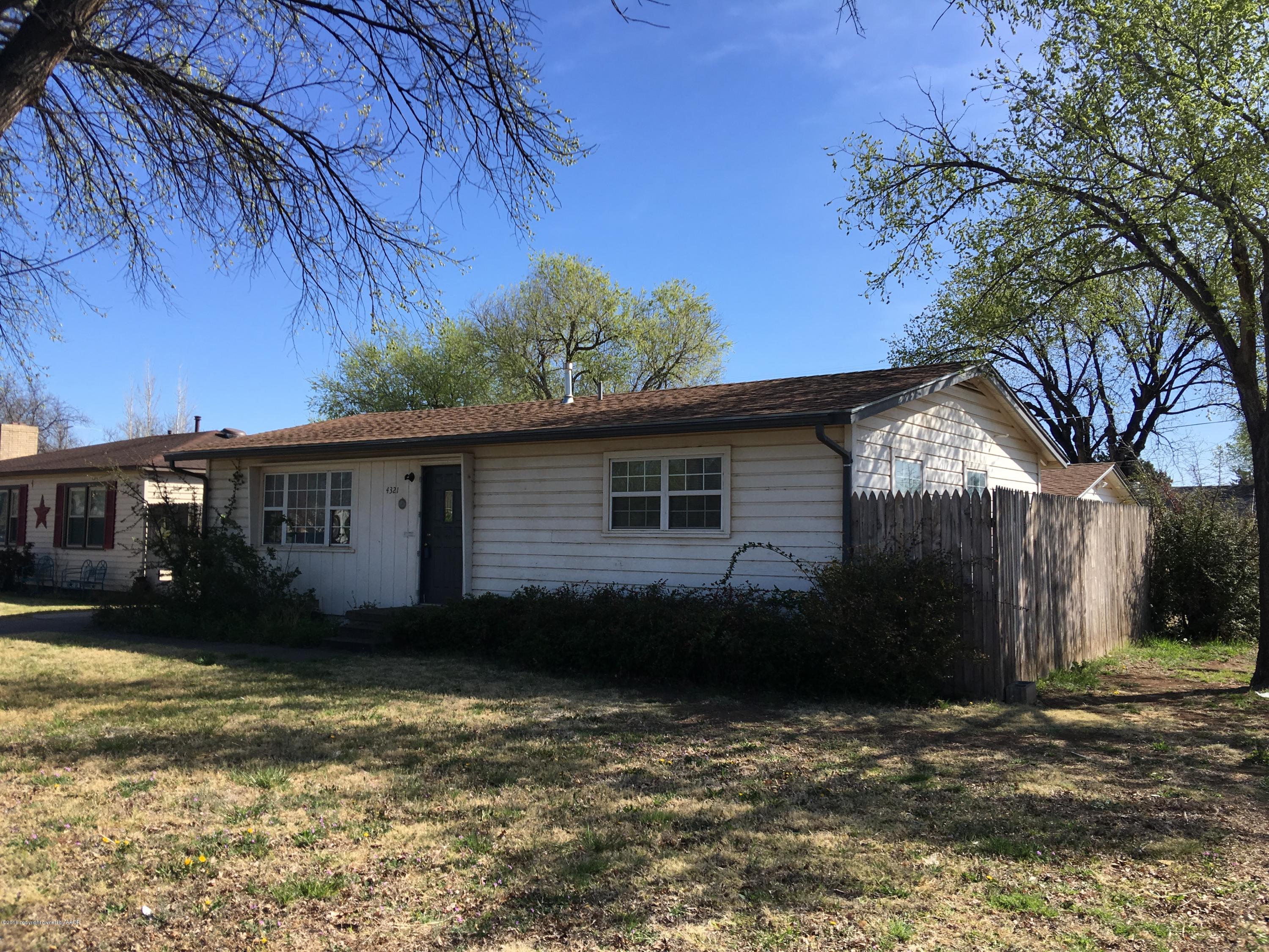 4321 South Travis Street Amarillo, TX 79110 - Photo 34 of 38 a view of a house next to a yard with large tree