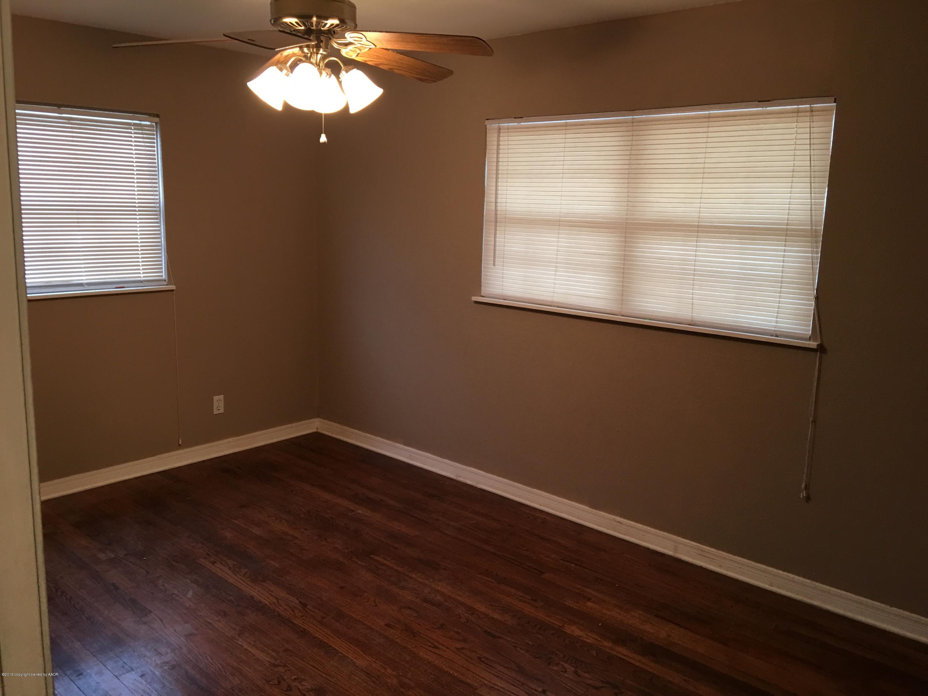 4321 South Travis Street Amarillo, TX 79110 - Photo 9 of 38 a view of an empty room with wooden floor and a window