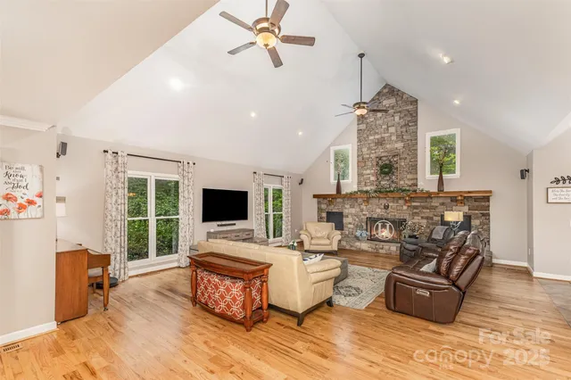 a living room with furniture a fireplace and a chandelier