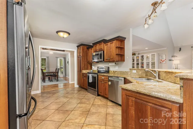 a kitchen with stainless steel appliances granite countertop a stove a sink and a microwave