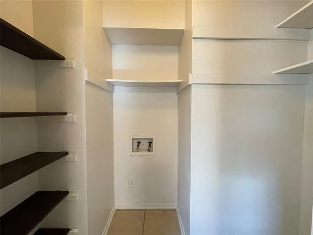 a view of walk in closet with empty racks