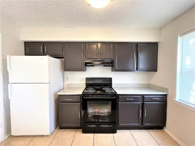 a kitchen with stainless steel appliances granite countertop a stove a refrigerator and a cabinets