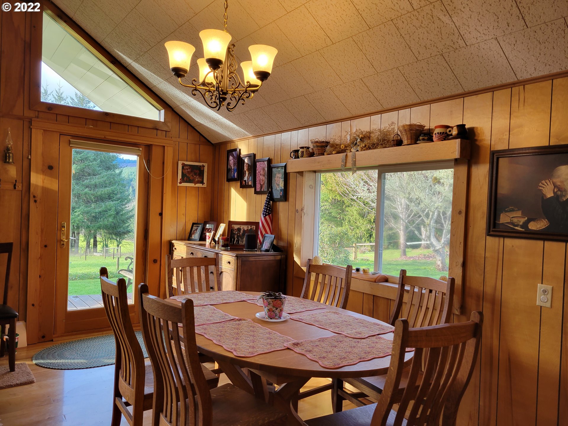 5064 Henderer Road Elkton, OR 97436 - Photo 6 of 32 a view of a dining room with furniture large window chandelier and wooden floor