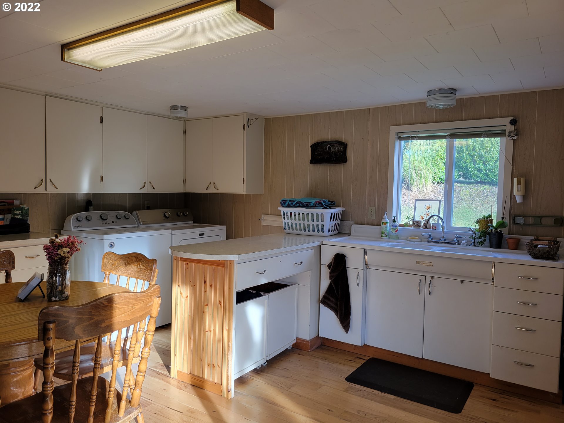 5064 Henderer Road Elkton, OR 97436 - Photo 10 of 32 a kitchen with a stove a sink a window and cabinets