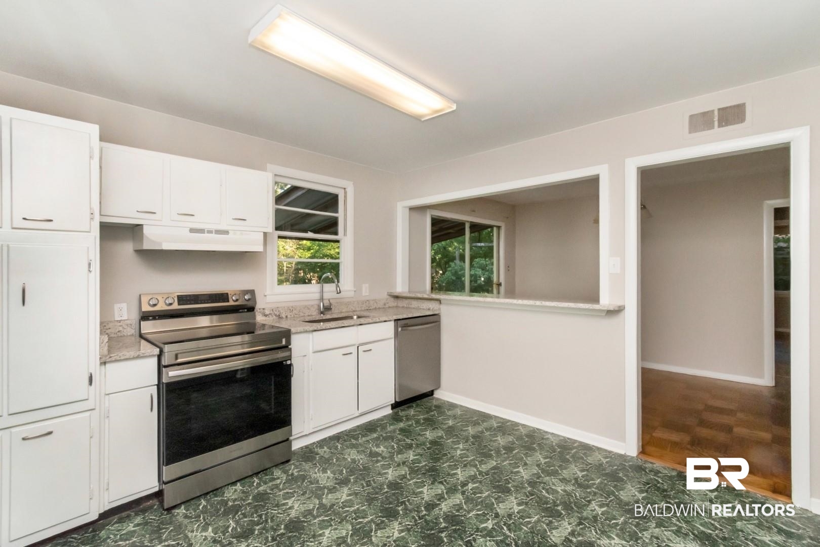 1220 Garland Drive Mobile, AL 36618 - Photo 10 of 25 Kitchen with premium range hood, dark parquet flooring, white cabinets, appliances with stainless steel finishes, and sink