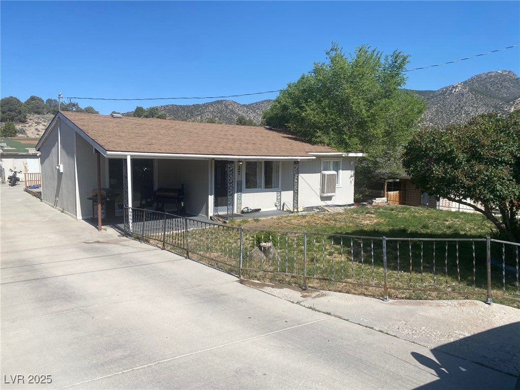 27 Carson Court Ely, NV 89301 - Photo 22 of 22 View of front of home featuring a fenced front yard, a mountain view, a porch, and stucco siding