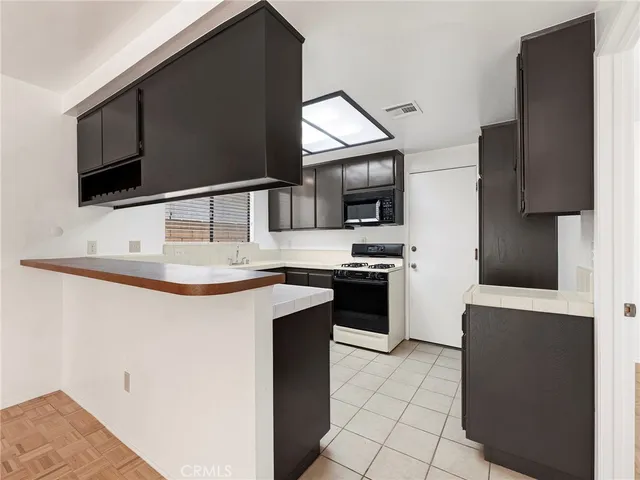 a kitchen with stainless steel appliances a stove microwave and refrigerator