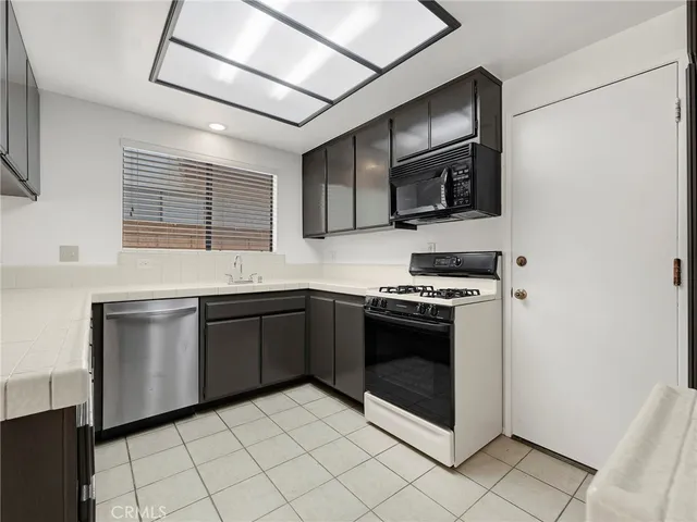 a kitchen with stainless steel appliances granite countertop a stove microwave and sink