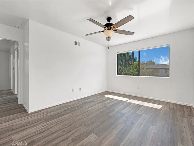 a view of a big room with wooden floor closet and fan