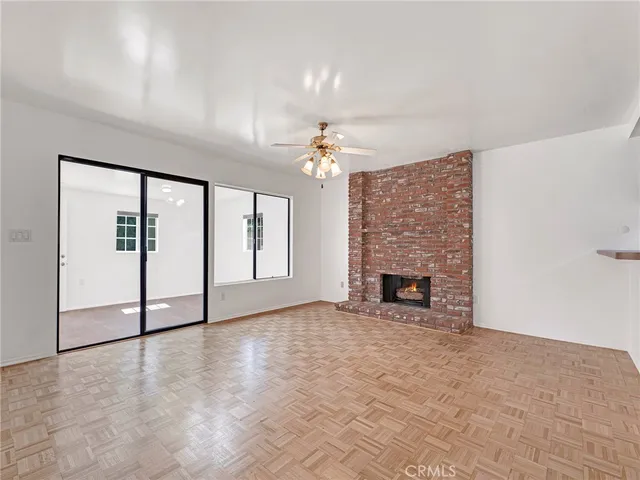 a view of an empty room with a fireplace and a window