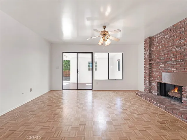 a view of an empty room with a fireplace and a window