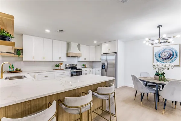 a kitchen with a dining table chairs sink and cabinets