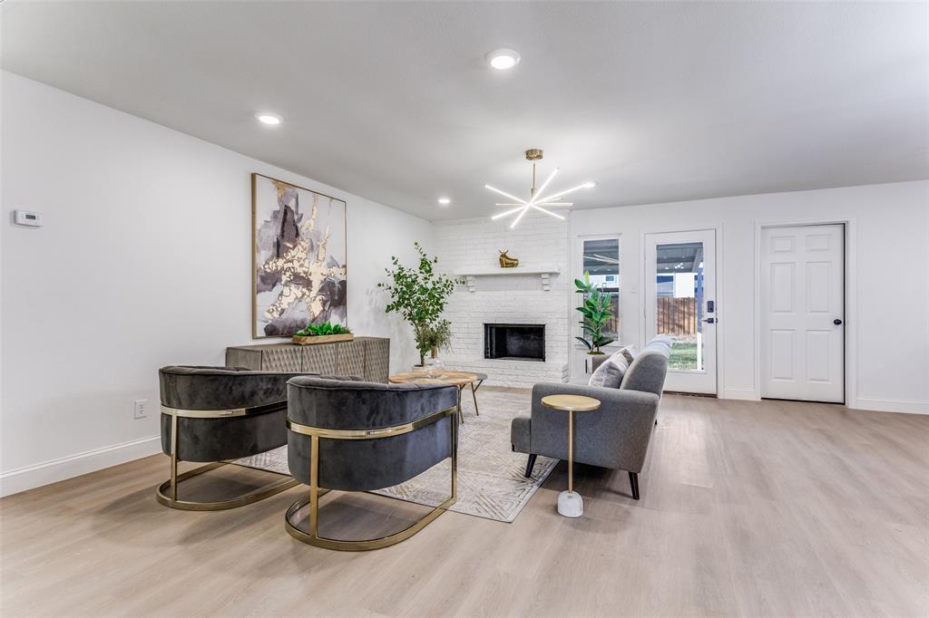 7609 Walnuthill Court Watauga, TX 76148 - Photo 7 of 22 a living room with furniture a table and a fireplace