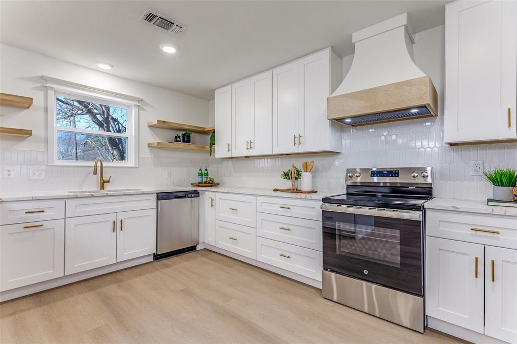7609 Walnuthill Court Watauga, TX 76148 - Photo 10 of 22 a kitchen with granite countertop white cabinets and stainless steel appliances