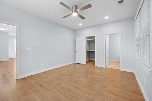 an empty room with closet and a ceiling fan