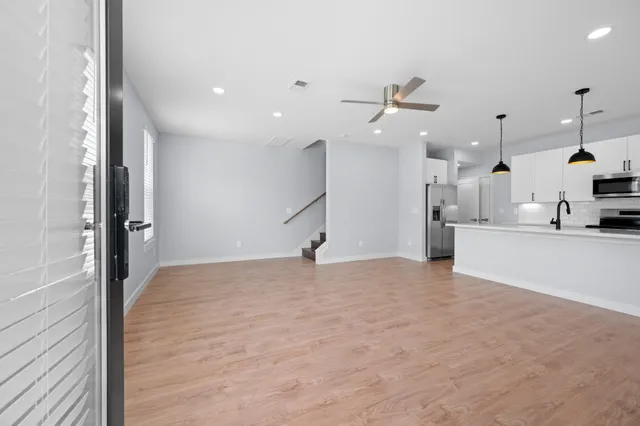 a view of a kitchen with kitchen island a sink stainless steel appliances and cabinets