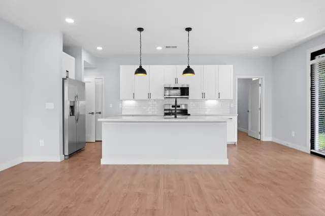 a view of kitchen with stainless steel appliances kitchen island a refrigerator and a sink