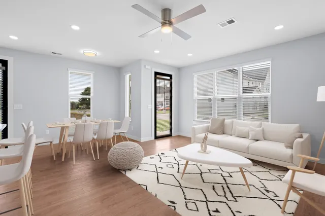 a living room with furniture two window and a table
