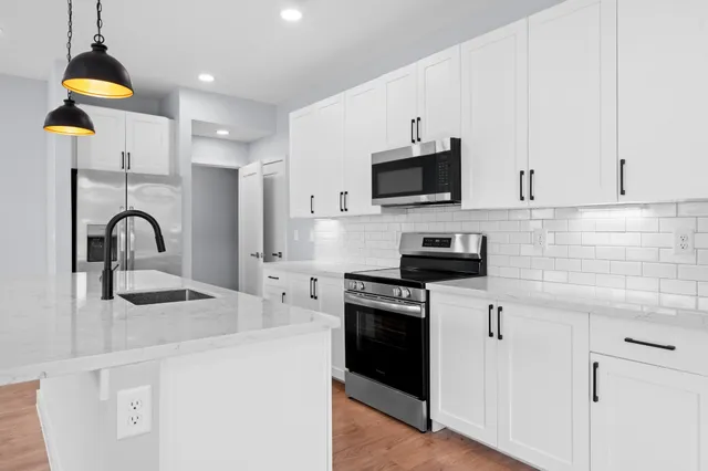 a kitchen with kitchen island a stove and a sink