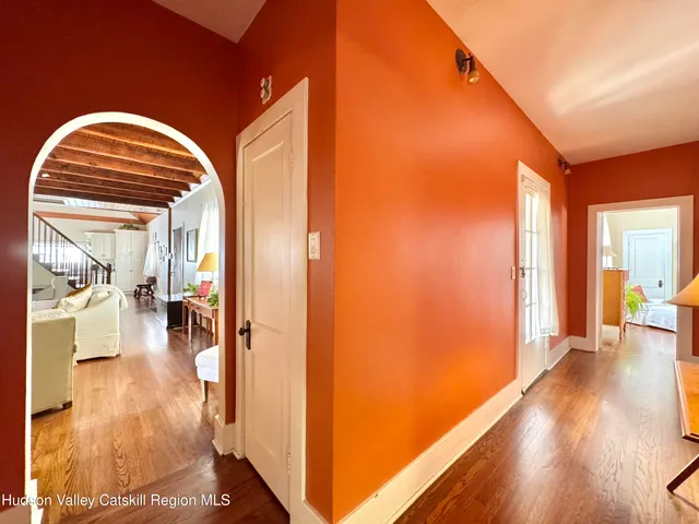 a view of a hallway with wooden floor and a living room