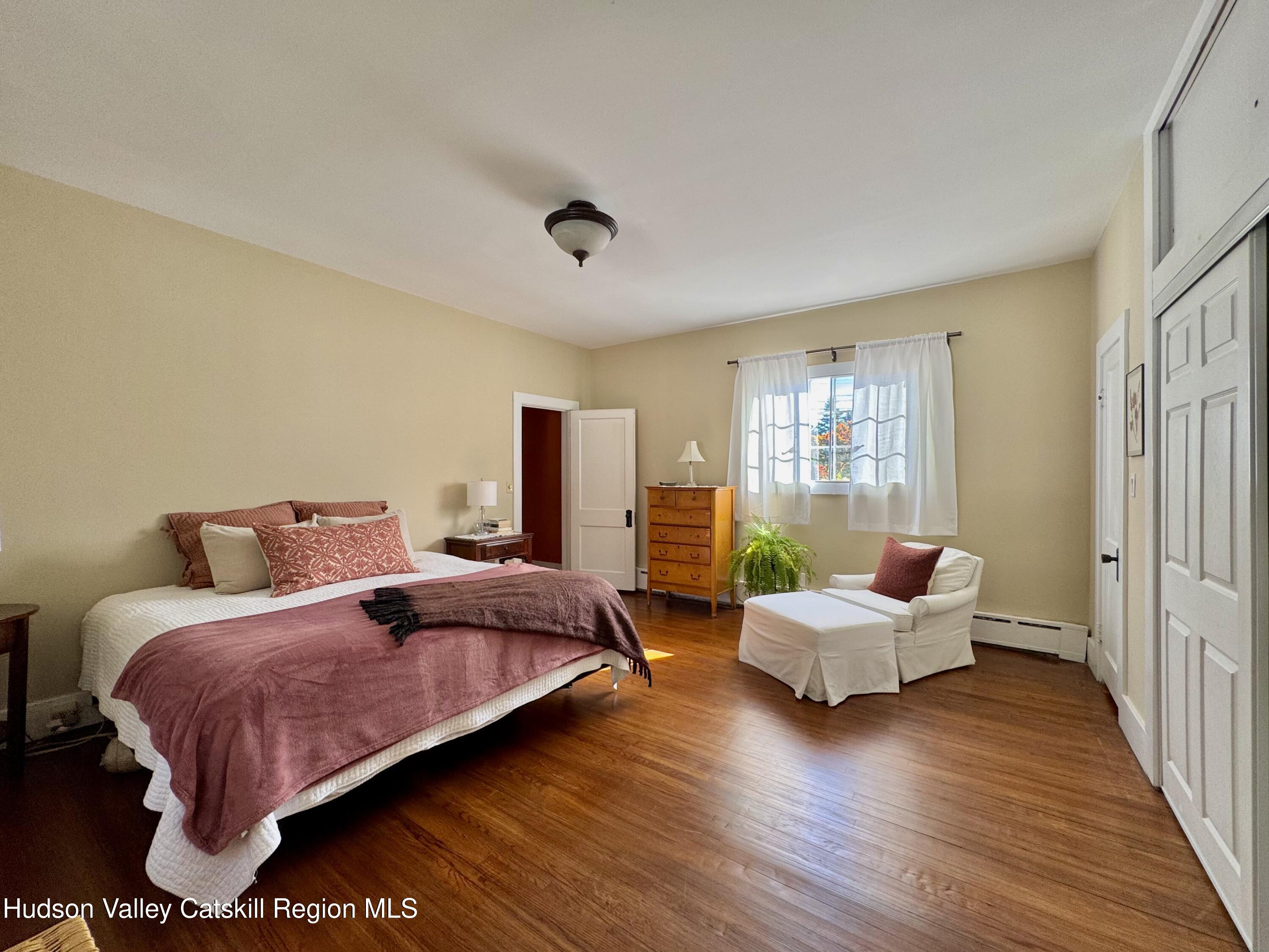 121 High Street Catskill, NY 12414 - Photo 16 of 29 a bedroom with a bed and wooden floor