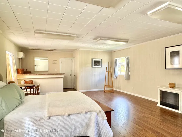 a spacious bedroom with a bed and wooden floor