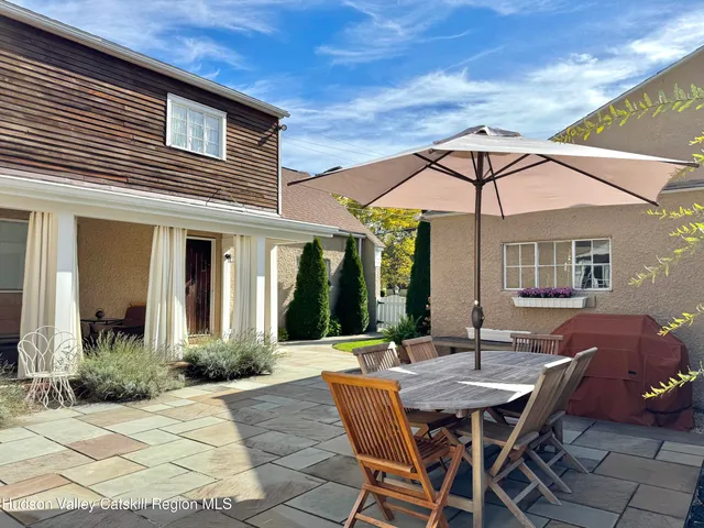 a patio with a table and chairs under an umbrella
