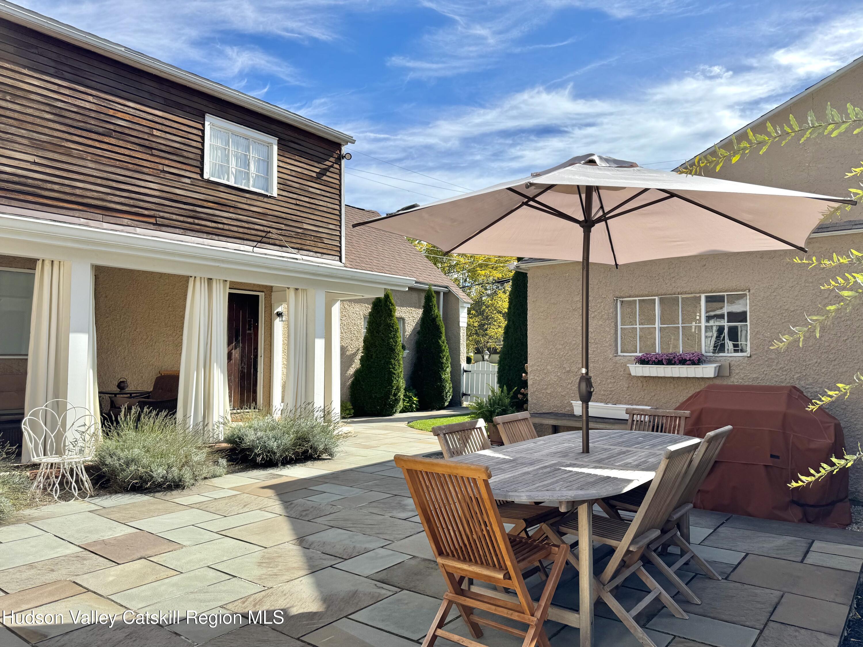121 High Street Catskill, NY 12414 - Photo 23 of 29 a patio with a table and chairs under an umbrella