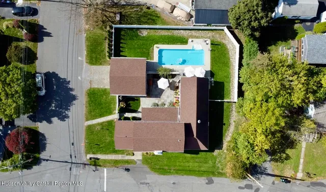 an aerial view of a house with a yard and large tree