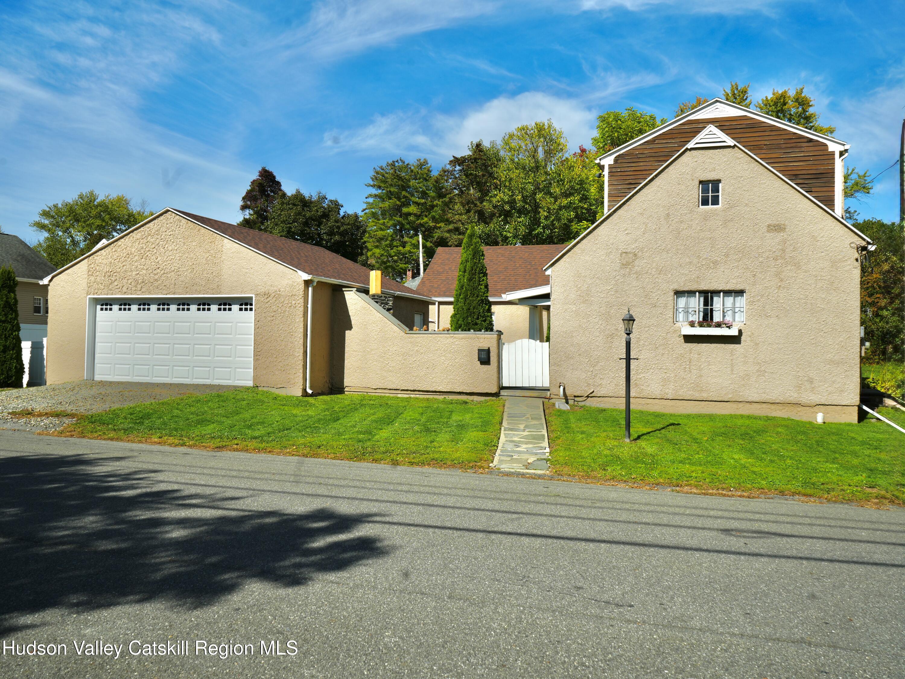 121 High Street Catskill, NY 12414 - Photo 3 of 29 a front view of a house with a yard and garage