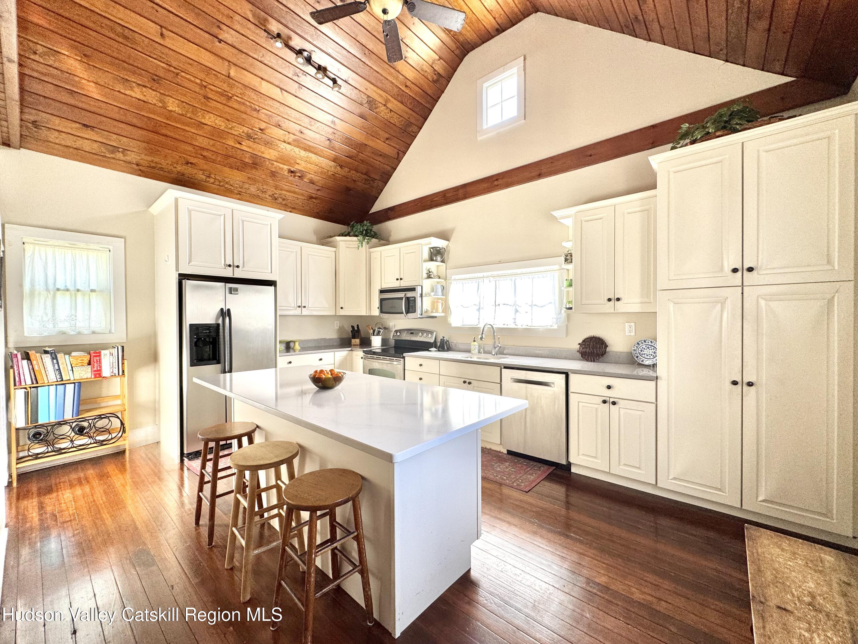 121 High Street Catskill, NY 12414 - Photo 10 of 29 a kitchen with stainless steel appliances kitchen island granite countertop a stove a sink a refrigerator and white cabinets with wooden floor