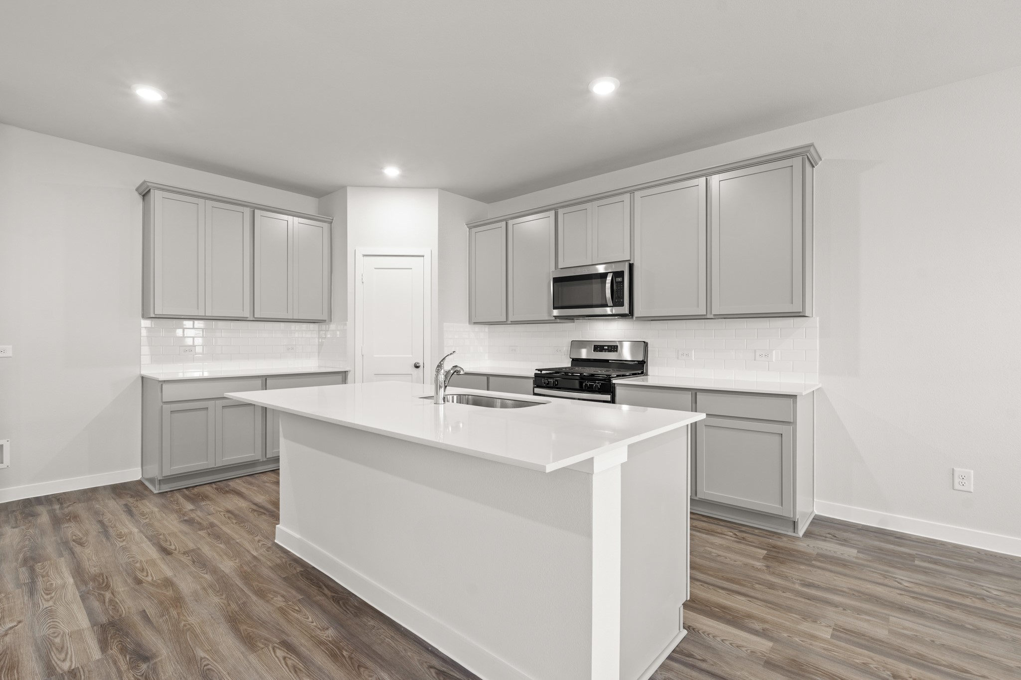 557 Wax Myrtle Way Hockley, TX 77447 - Photo 11 of 25 a kitchen with a sink a stove a refrigerator and white cabinets
