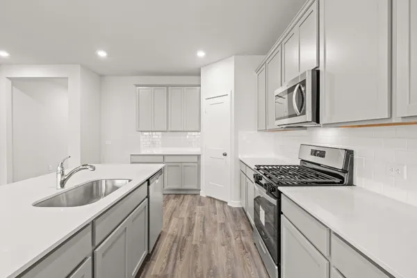 a kitchen that has a sink and a stove top oven